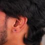 Close-up of  man's ear with a small heart earring