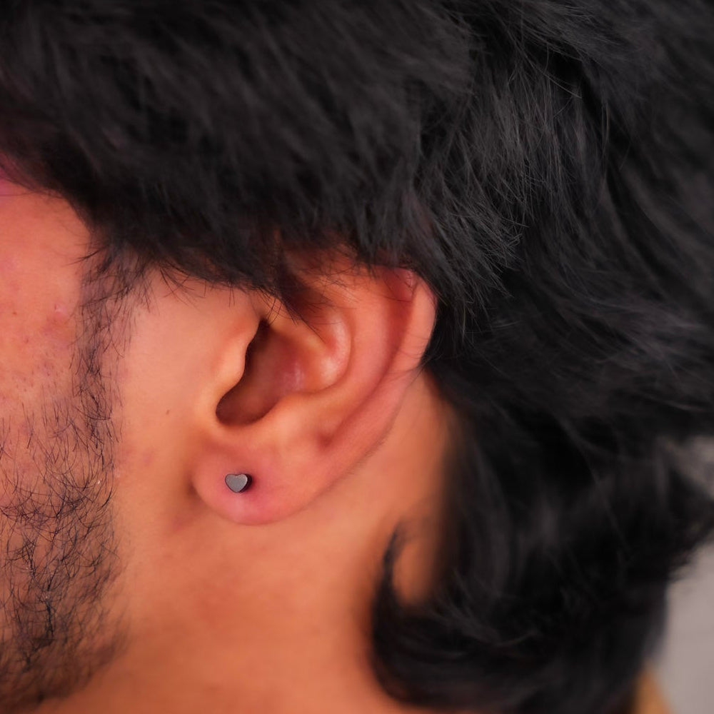 Close-up of  man's ear with a small heart earring